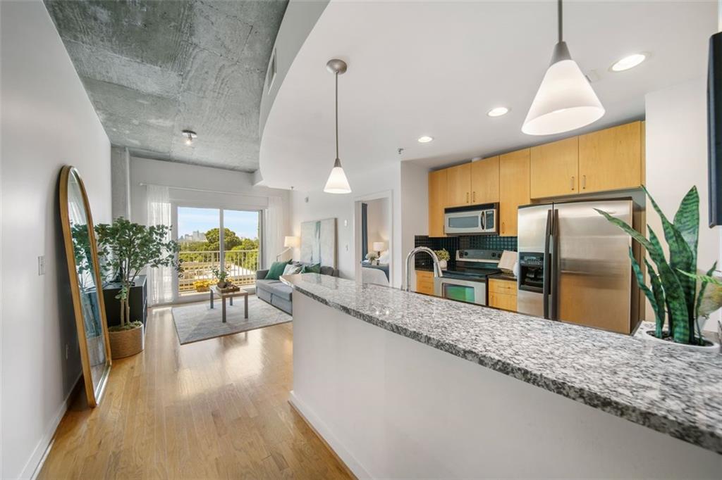 250 Pharr Road Northeast, Unit 412 Atlanta, GA 30305 - Photo 18 of 49 a kitchen with stainless steel appliances kitchen island granite countertop a refrigerator a stove and a sink
