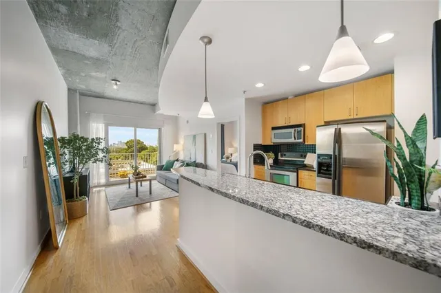 a kitchen with stainless steel appliances kitchen island granite countertop a refrigerator a stove and a sink