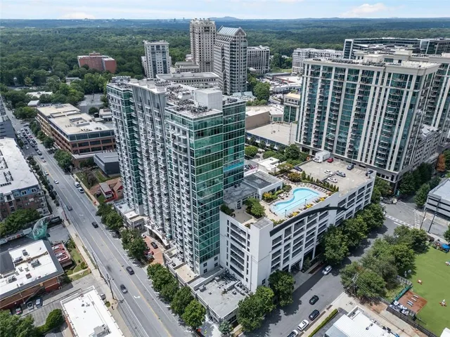 a front view of a building with lot of cars and trees