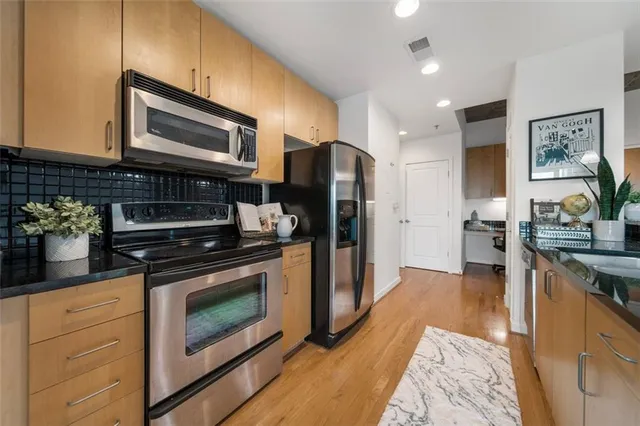 a kitchen with stainless steel appliances granite countertop a stove a refrigerator and a microwave