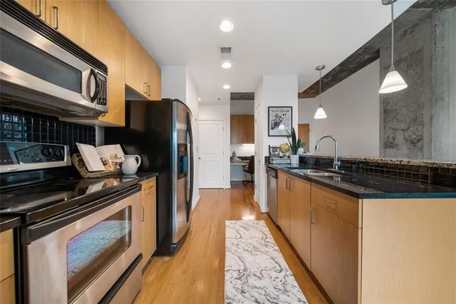 a kitchen with stainless steel appliances granite countertop a stove a refrigerator and a microwave