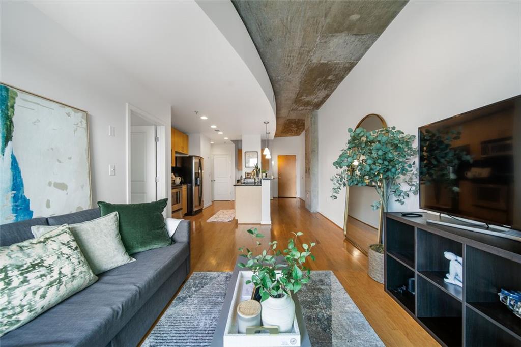 250 Pharr Road Northeast, Unit 412 Atlanta, GA 30305 - Photo 10 of 49 a living room with furniture and a flat screen tv