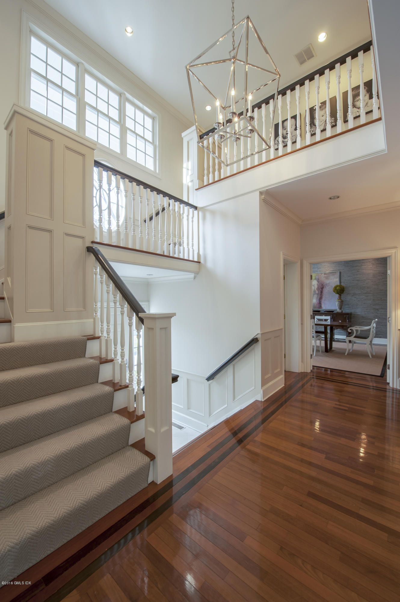 175 Stanwich Road Greenwich, CT 06830 - Photo 3 of 21 a view of staircase and kitchen with wooden floor and pendant lights
