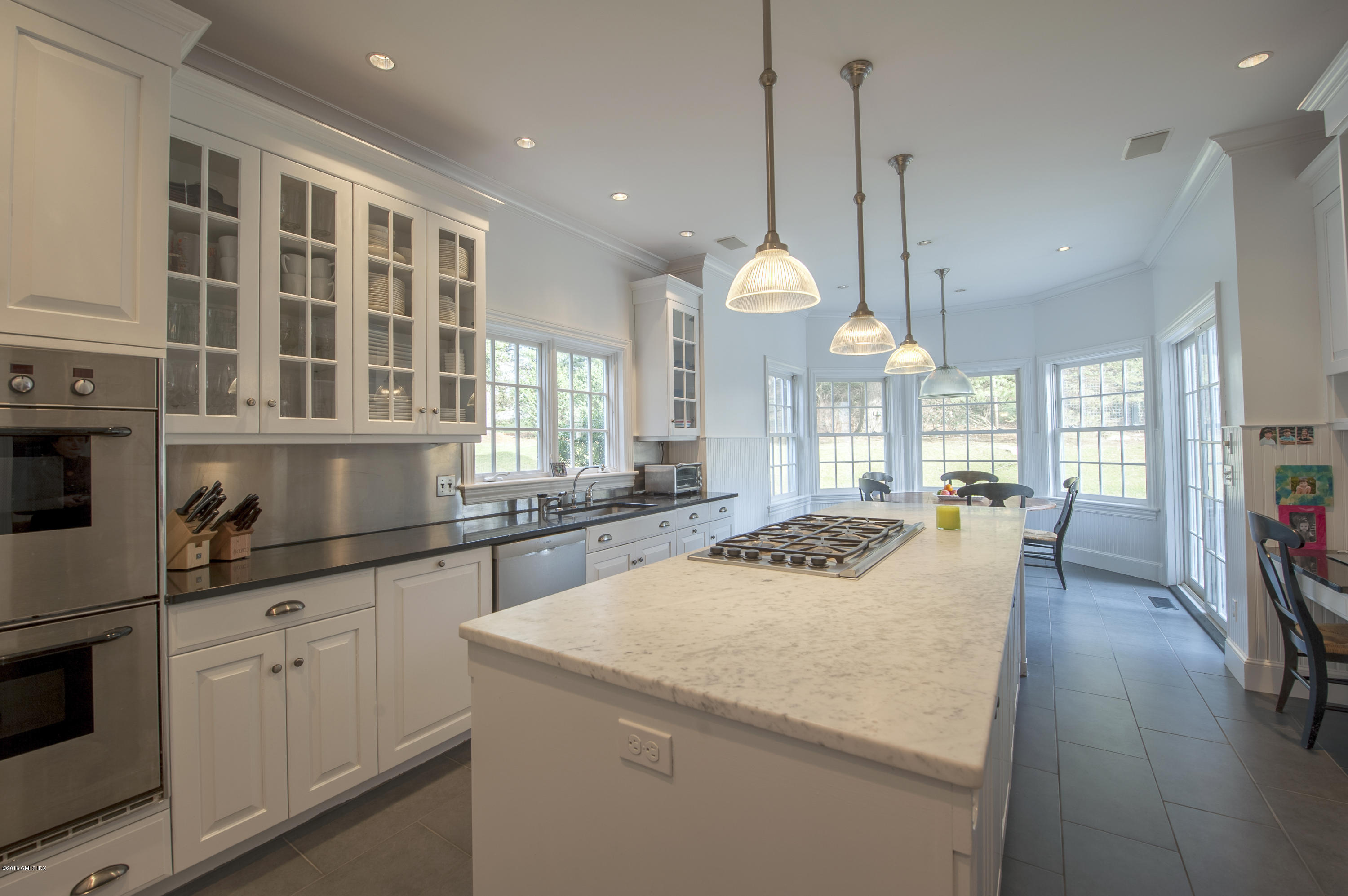 175 Stanwich Road Greenwich, CT 06830 - Photo 6 of 21 a kitchen with stainless steel appliances granite countertop a stove a sink a oven and a dining table with white cabinets