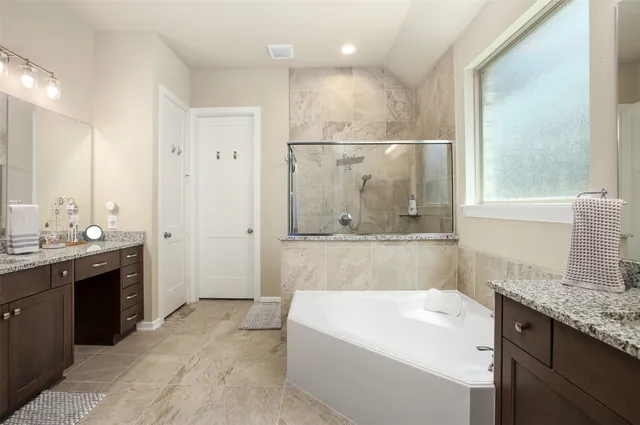 a bathroom with a granite countertop sink mirror and a bathtub