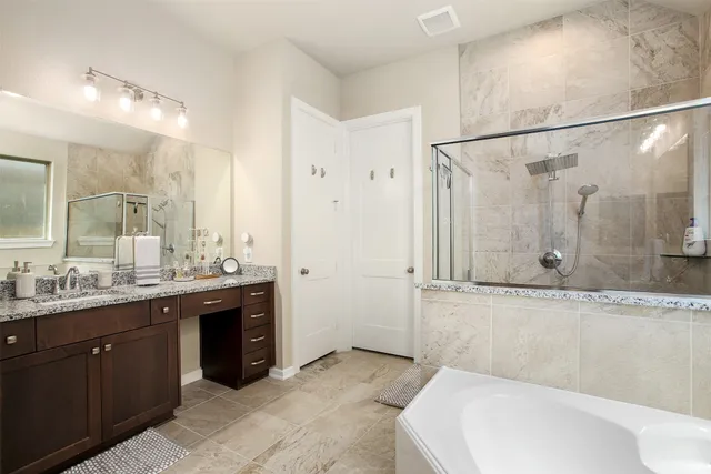 a bathroom with a granite countertop sink mirror and a bathtub