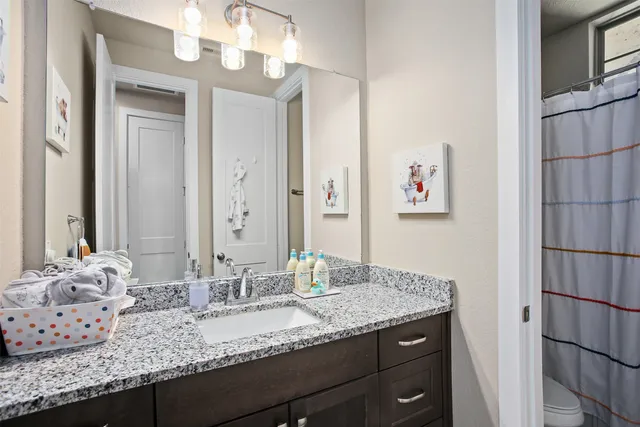 a bathroom with a granite countertop sink and a mirror