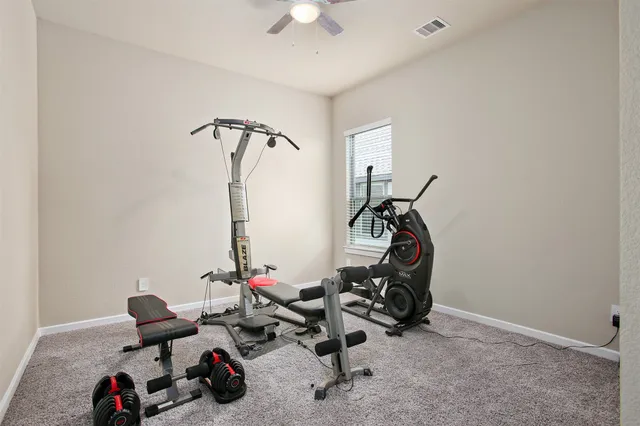 a room with gym equipment and wooden floor