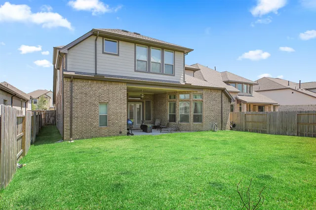 a view of a big house with a big yard and large trees
