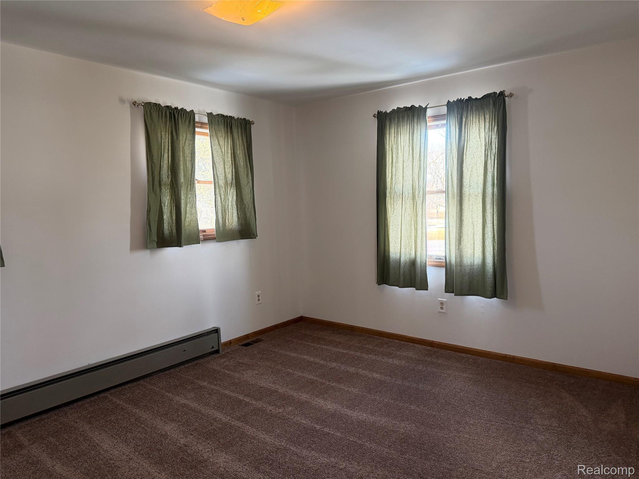 5749 Leix Road Mayville, MI 48744 - Photo 24 of 44 Spare room with baseboard heating and dark carpet