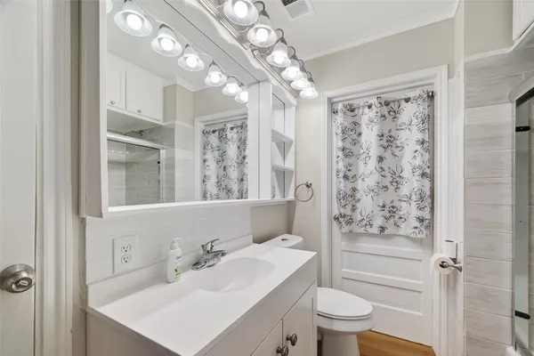 a bathroom with a sink a toilet and shower