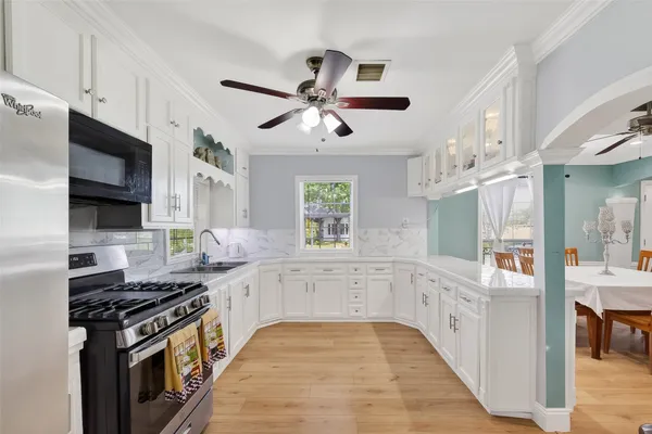 a kitchen with stainless steel appliances a sink dishwasher stove and white cabinets