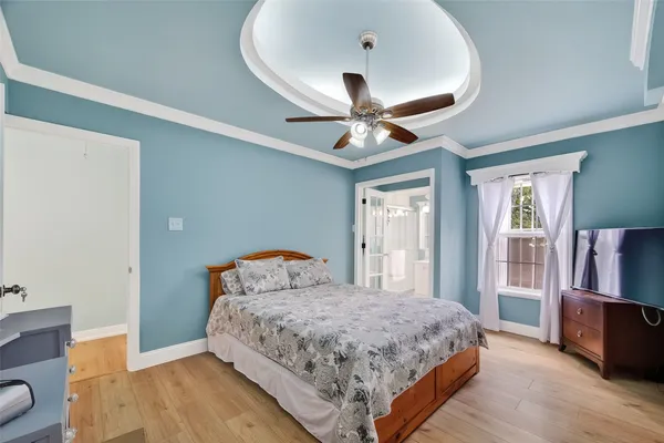 a bedroom with a large bed and a chandelier