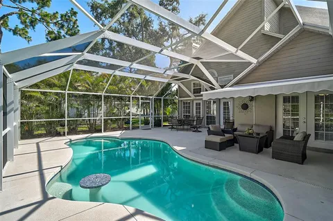 a view of a patio with table and chairs and floor to ceiling window