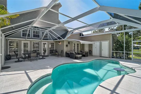 a view of a house with pool and sitting area
