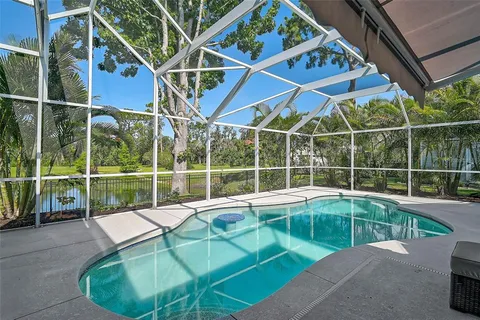 a view of a lake with a yard and large trees