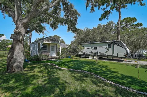 an aerial view of residential houses with outdoor space and trees