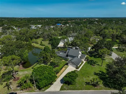 an aerial view of residential houses with outdoor space and trees