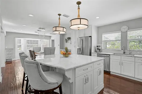 a kitchen that has a lot of cabinets in it and wooden floor