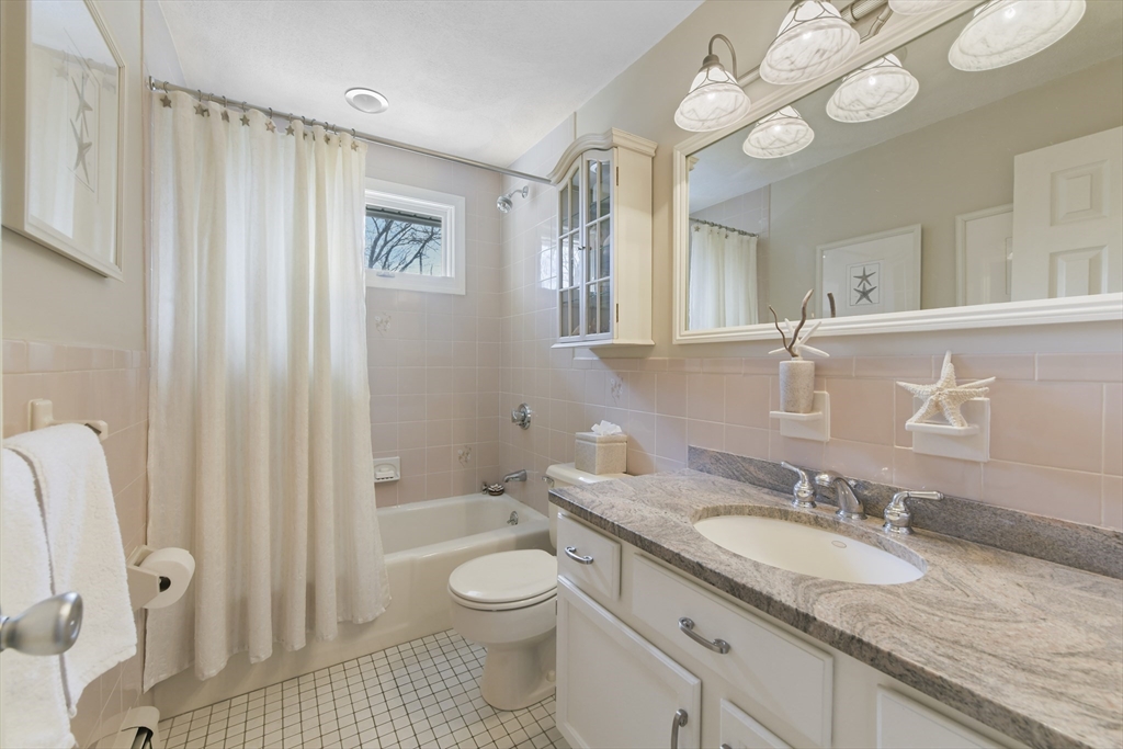 4 Coach Lane Dedham, MA 02026 - Photo 14 of 32 a bathroom with a granite countertop sink a toilet and a large mirror