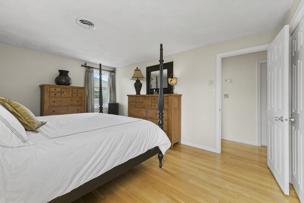 4 Coach Lane Dedham, MA 02026 - Photo 15 of 32 a bedroom with a bed and wooden floor