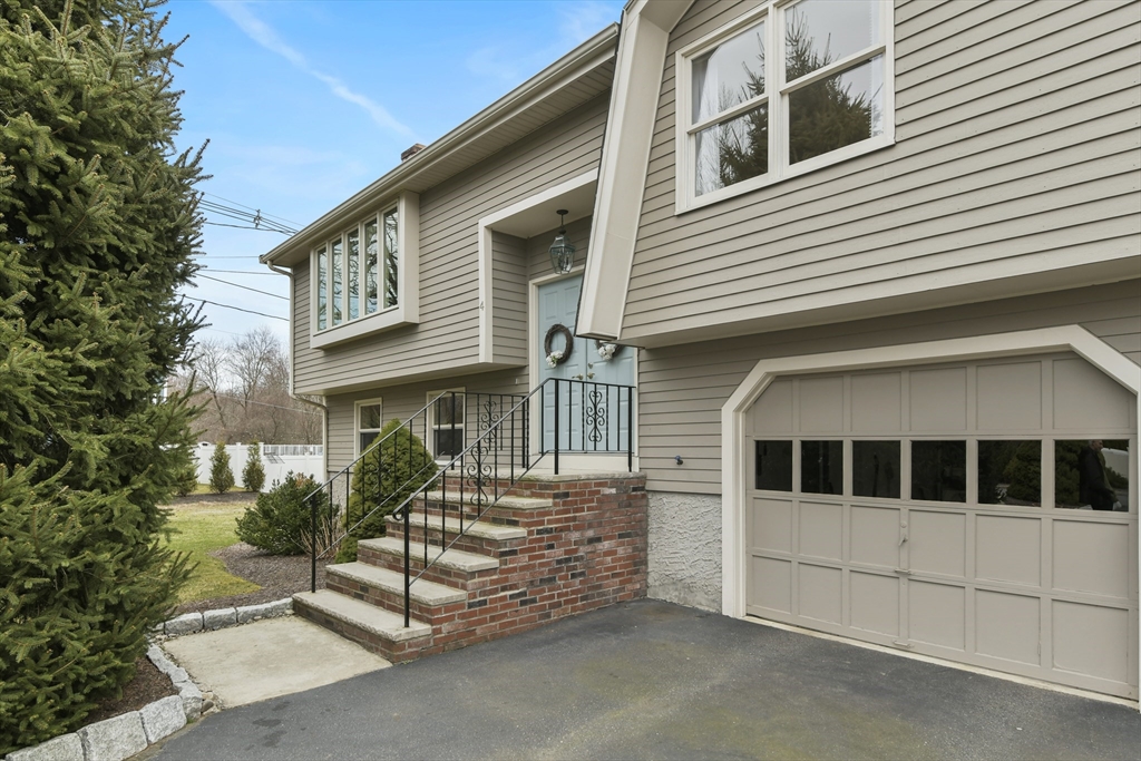 4 Coach Lane Dedham, MA 02026 - Photo 26 of 32 a front view of a house with garage
