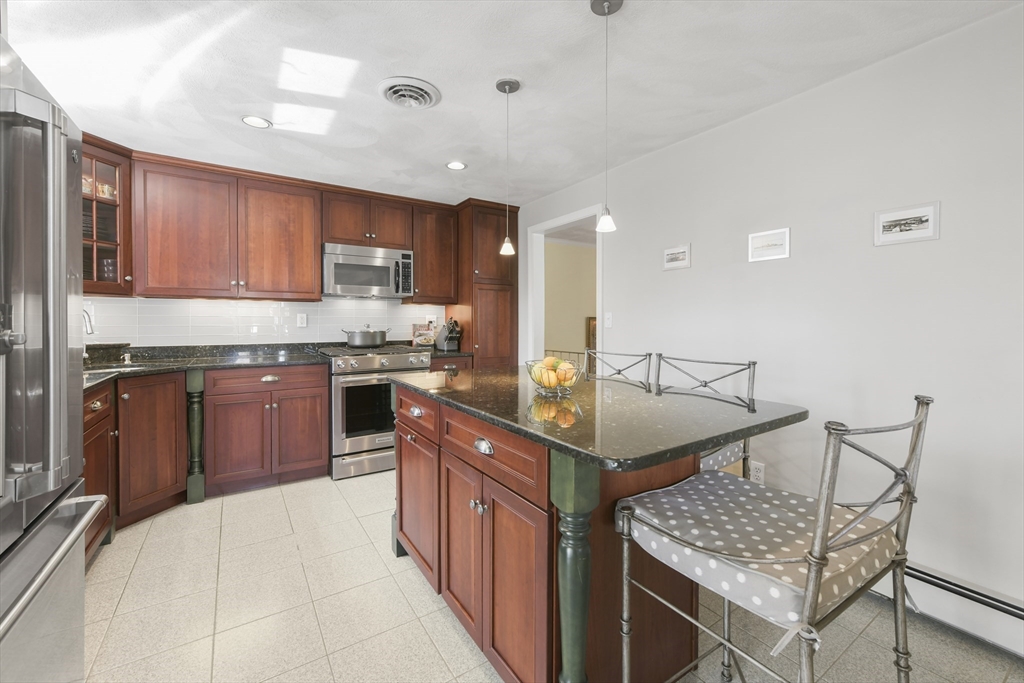 4 Coach Lane Dedham, MA 02026 - Photo 4 of 32 a kitchen with stainless steel appliances granite countertop a sink stove and refrigerator