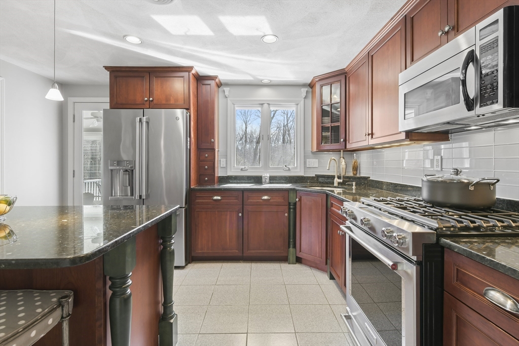 4 Coach Lane Dedham, MA 02026 - Photo 7 of 32 a kitchen with stainless steel appliances granite countertop a stove a sink and a refrigerator