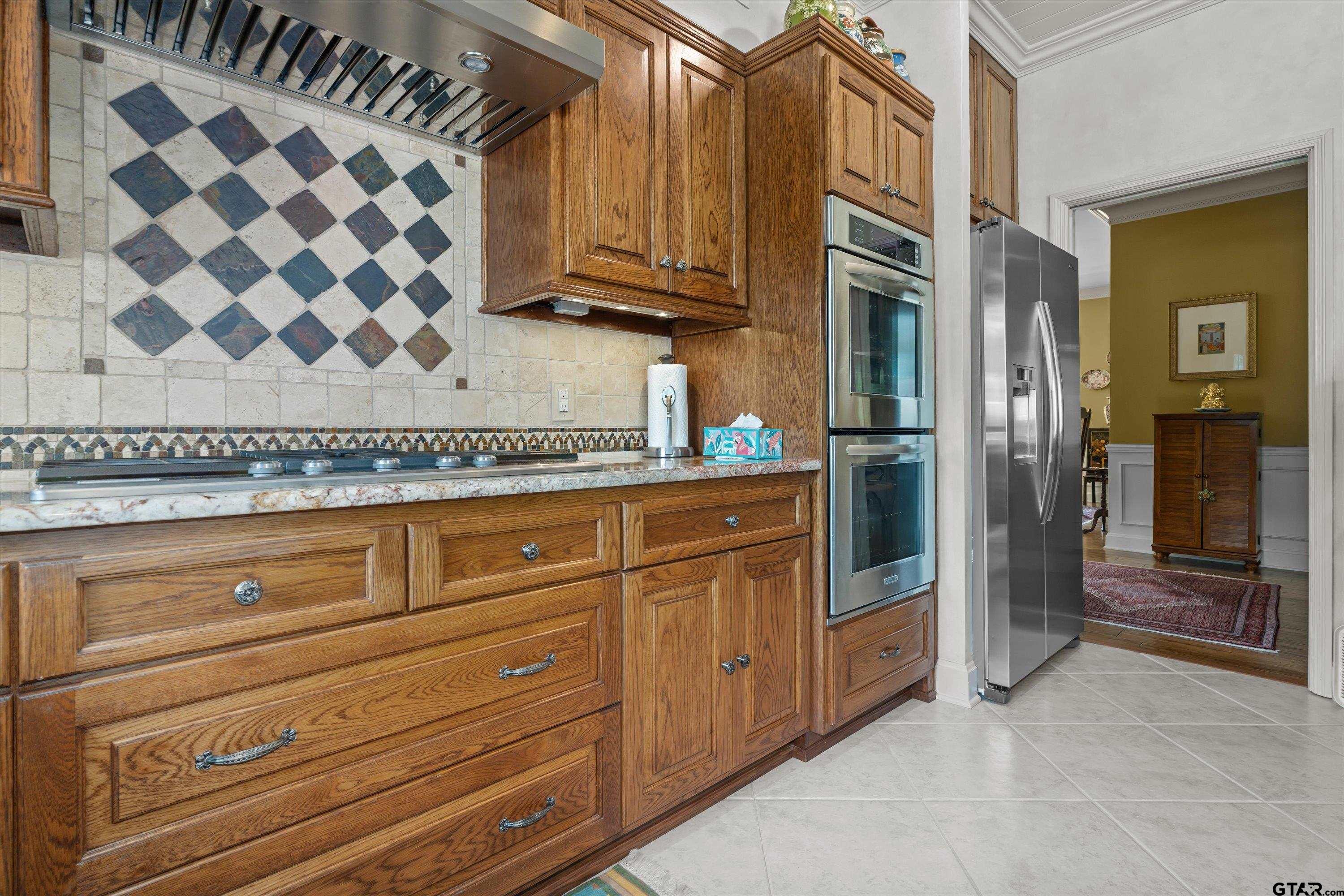121 Fair Lane Tyler, TX 75701 - Photo 18 of 46 a kitchen with stainless steel appliances granite countertop a refrigerator and a stove