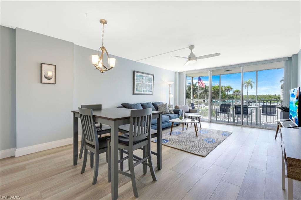5 Bluebill Avenue, Unit 210 Naples, FL 34108 - Photo 11 of 26 a view of a dining room with furniture window and wooden floor