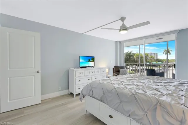 a bedroom with a bed and large windows