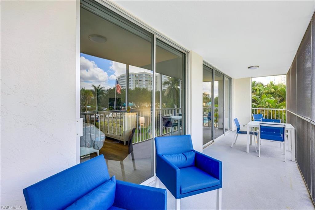 5 Bluebill Avenue, Unit 210 Naples, FL 34108 - Photo 19 of 26 a living room with furniture and a floor to ceiling window