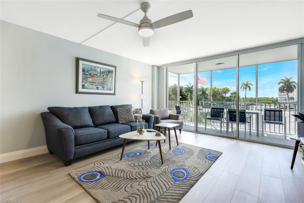 5 Bluebill Avenue, Unit 210 Naples, FL 34108 - Photo 3 of 26 a living room with furniture and a large window