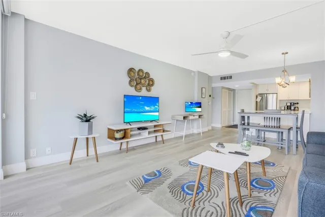 a living room with furniture and a dining table with wooden floor