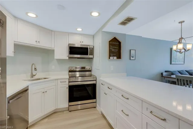 a kitchen with stainless steel appliances granite countertop a sink and a stove top oven
