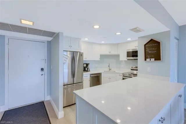a kitchen with stainless steel appliances a refrigerator stove microwave and cabinets