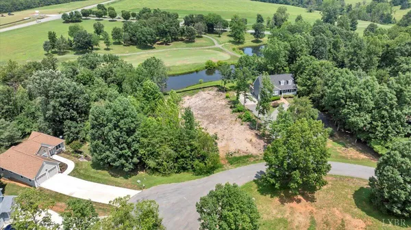an aerial view of residential house with outdoor space and trees all around
