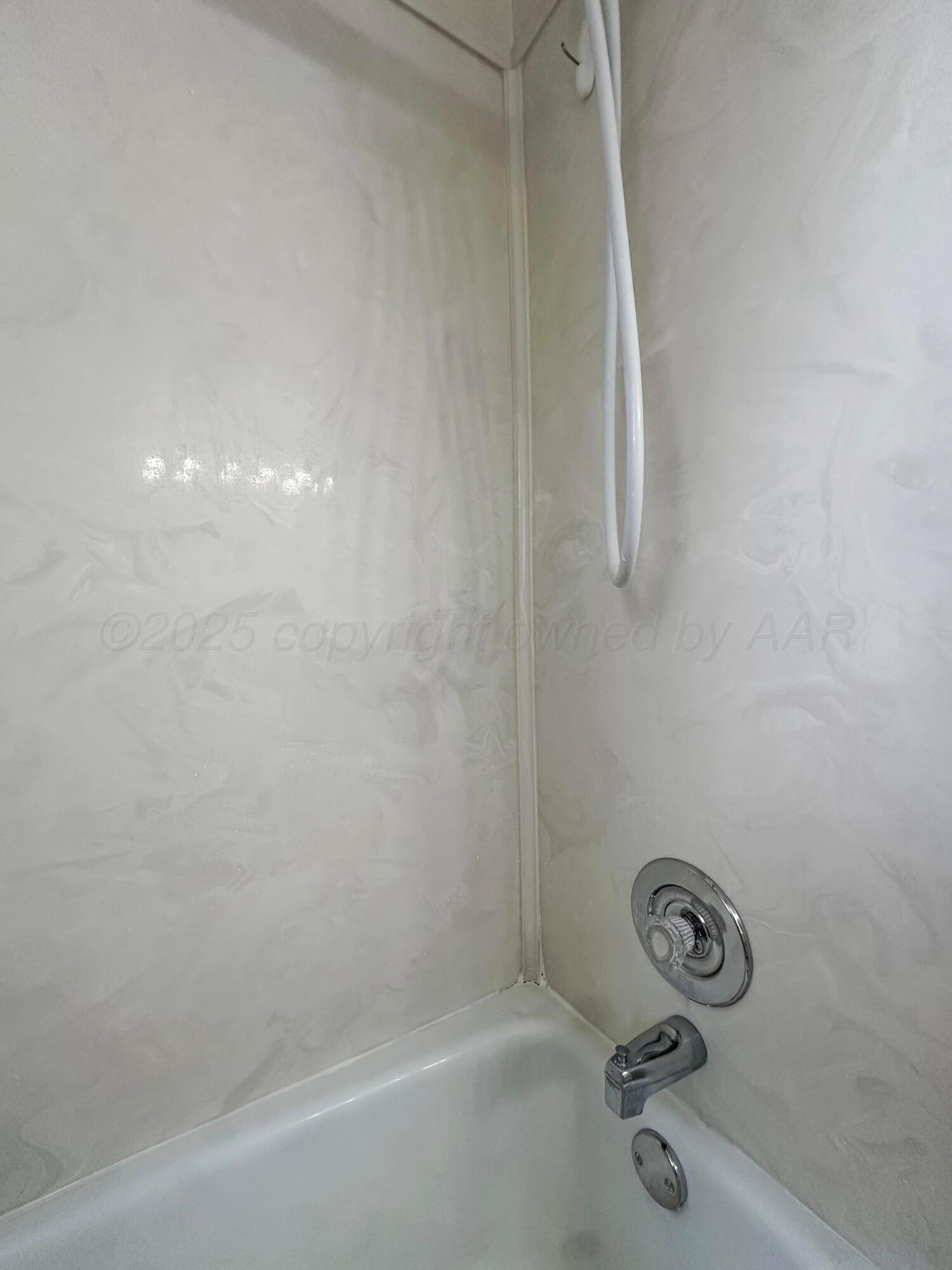 1421 Marigold Street Borger, TX 79007 - Photo 12 of 26 a bath tub sitting next to a white sink and a shower