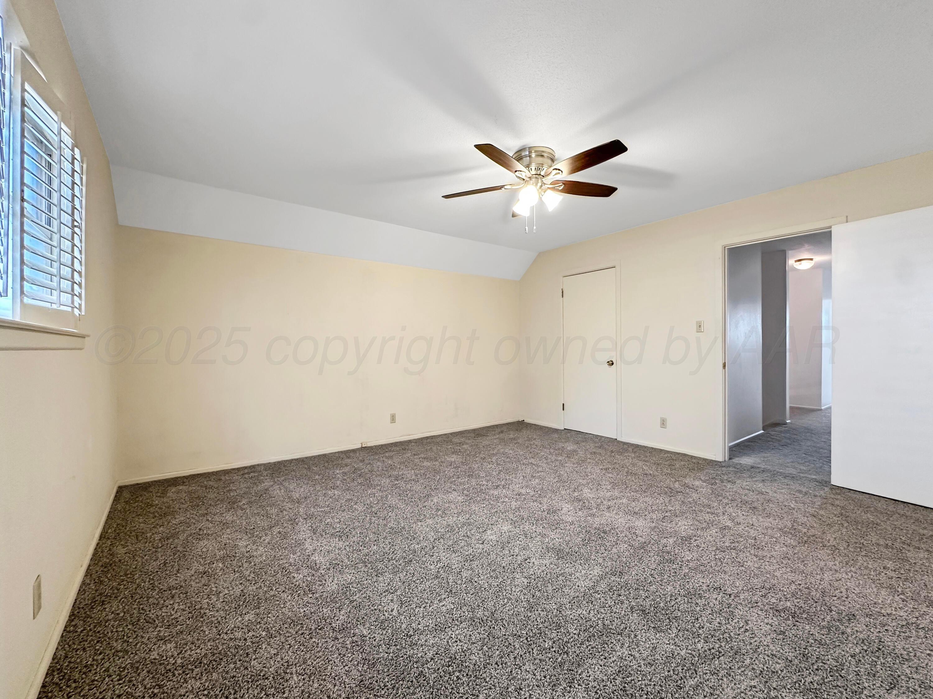 1421 Marigold Street Borger, TX 79007 - Photo 14 of 26 an empty room with a chandelier fan and windows