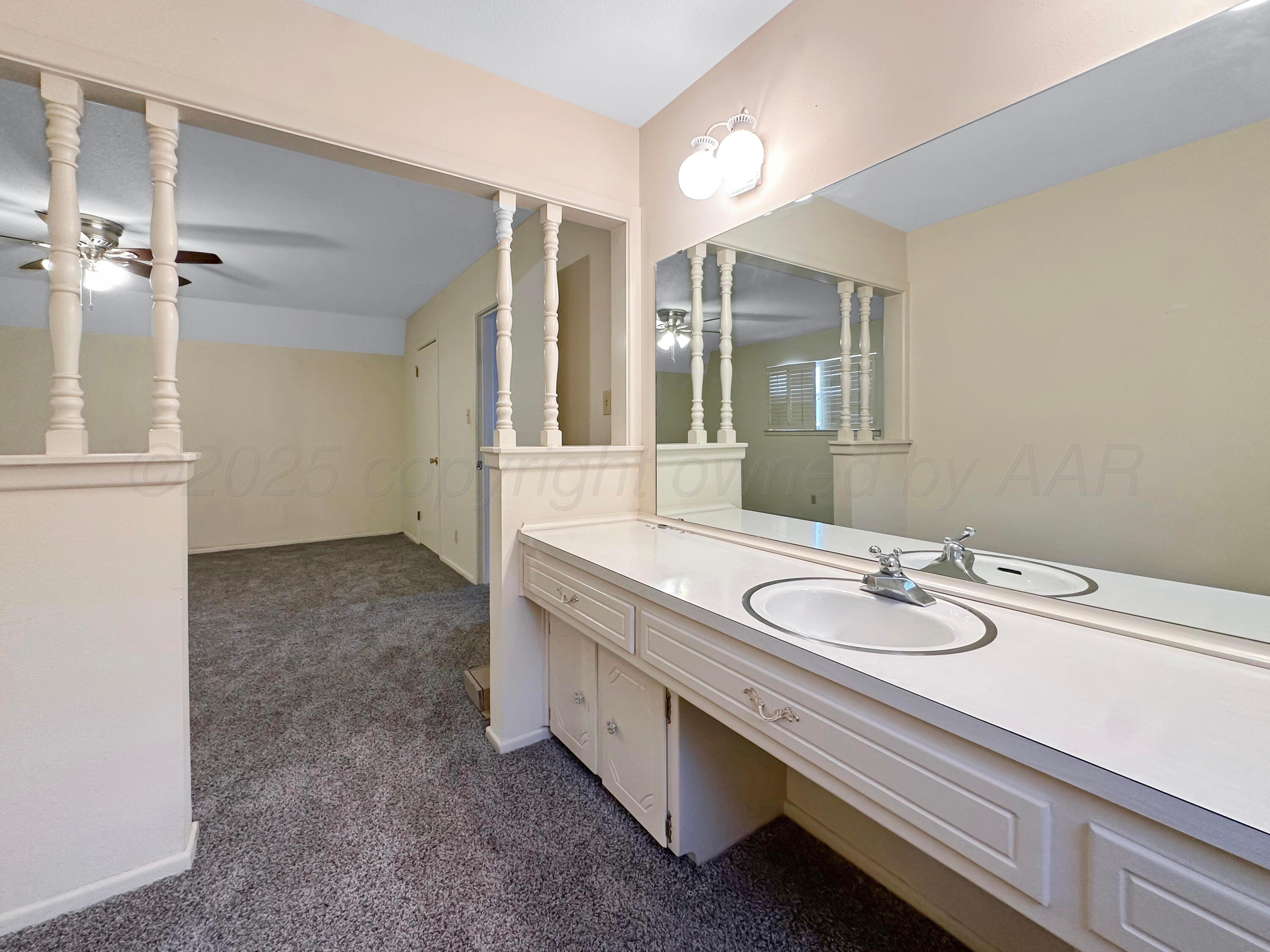 1421 Marigold Street Borger, TX 79007 - Photo 15 of 26 a spacious bathroom with a double vanity sink and a mirror
