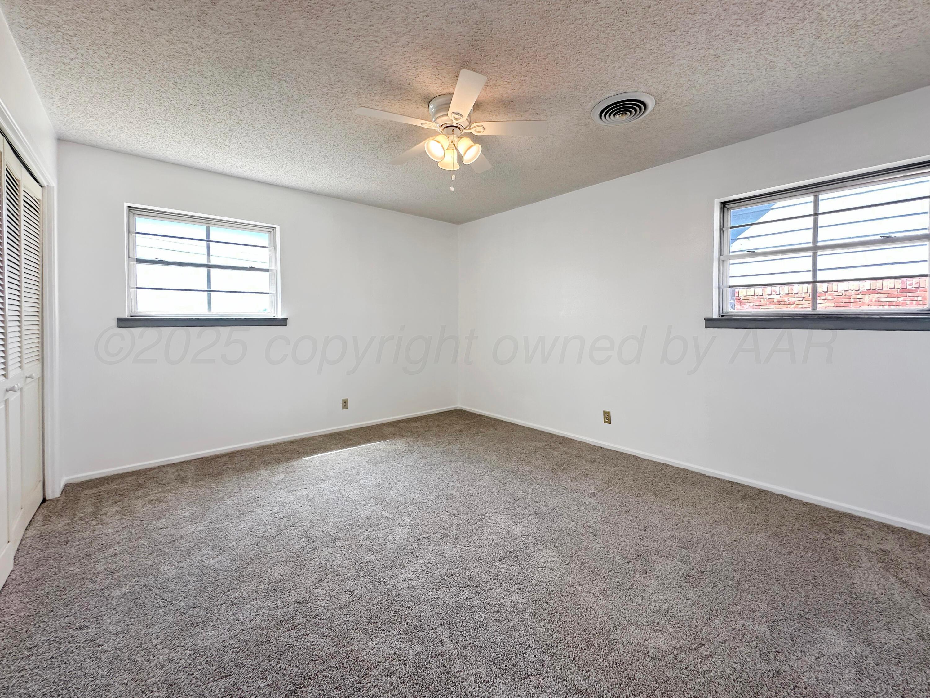 1421 Marigold Street Borger, TX 79007 - Photo 21 of 26 an empty room with a window and a ceiling fan