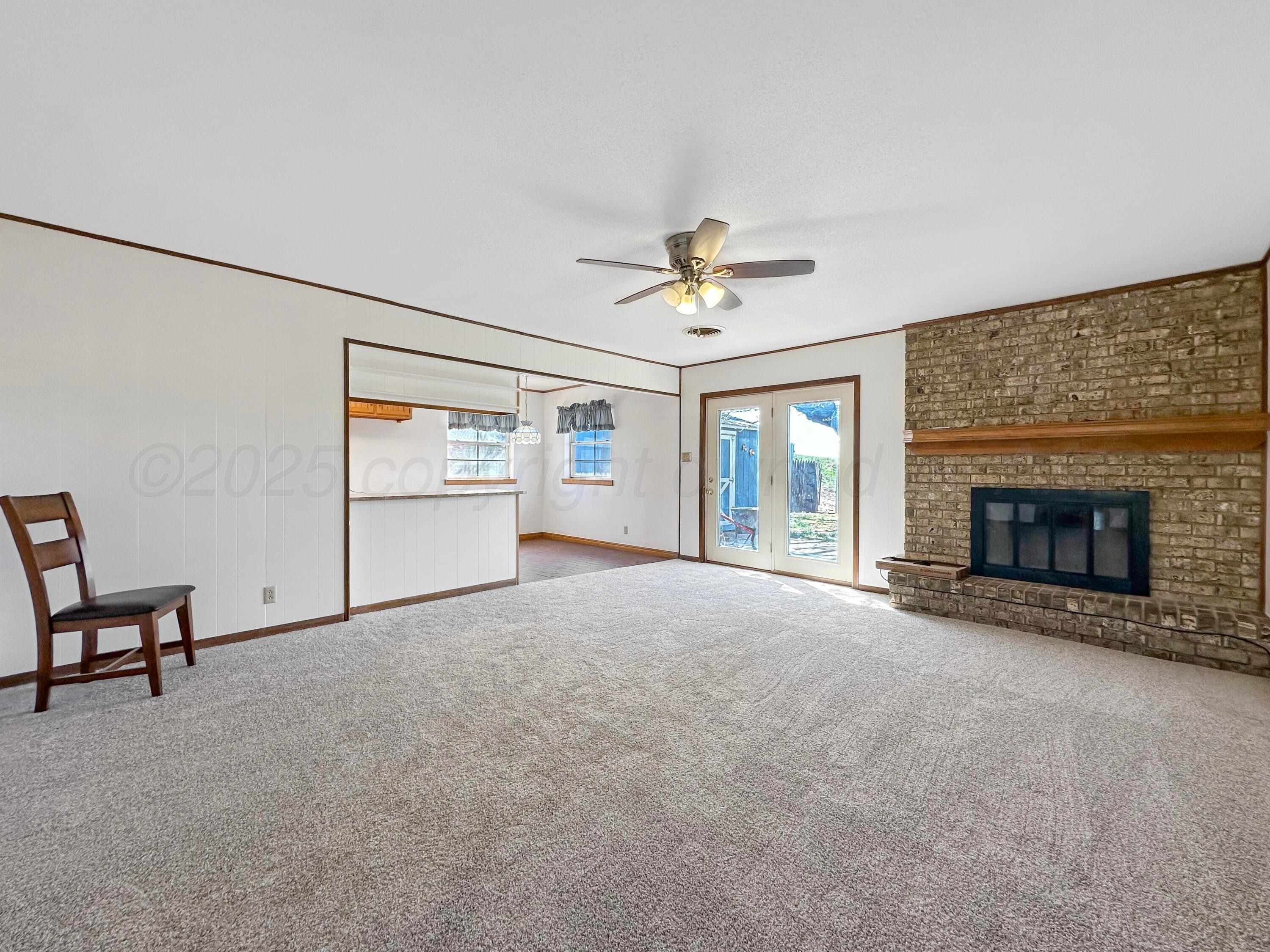 1421 Marigold Street Borger, TX 79007 - Photo 5 of 26 a view of an empty room with a fireplace and a window