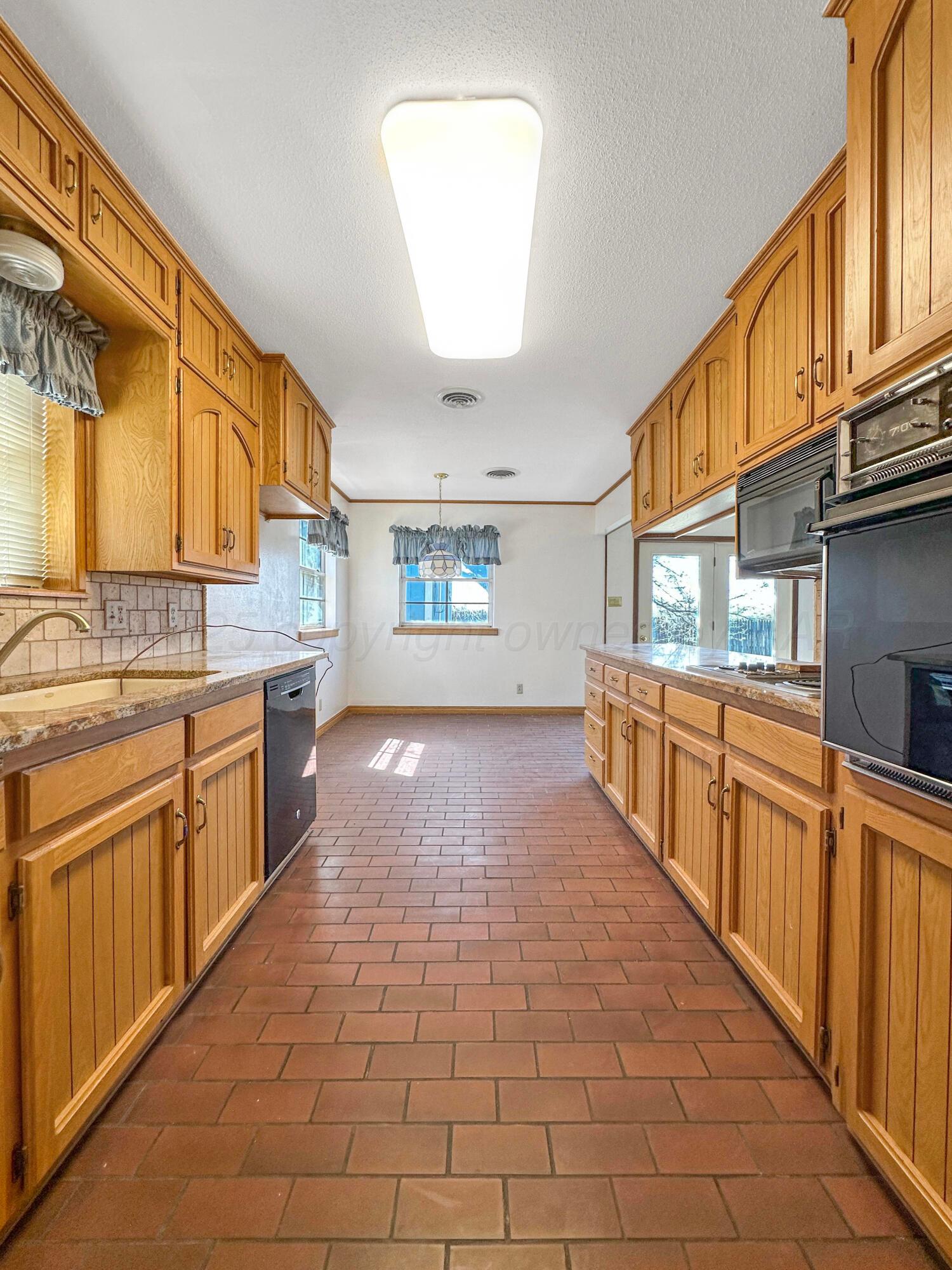 1421 Marigold Street Borger, TX 79007 - Photo 7 of 26 a large kitchen with stainless steel appliances granite countertop a large stove a sink dishwasher and cabinets with wooden floor