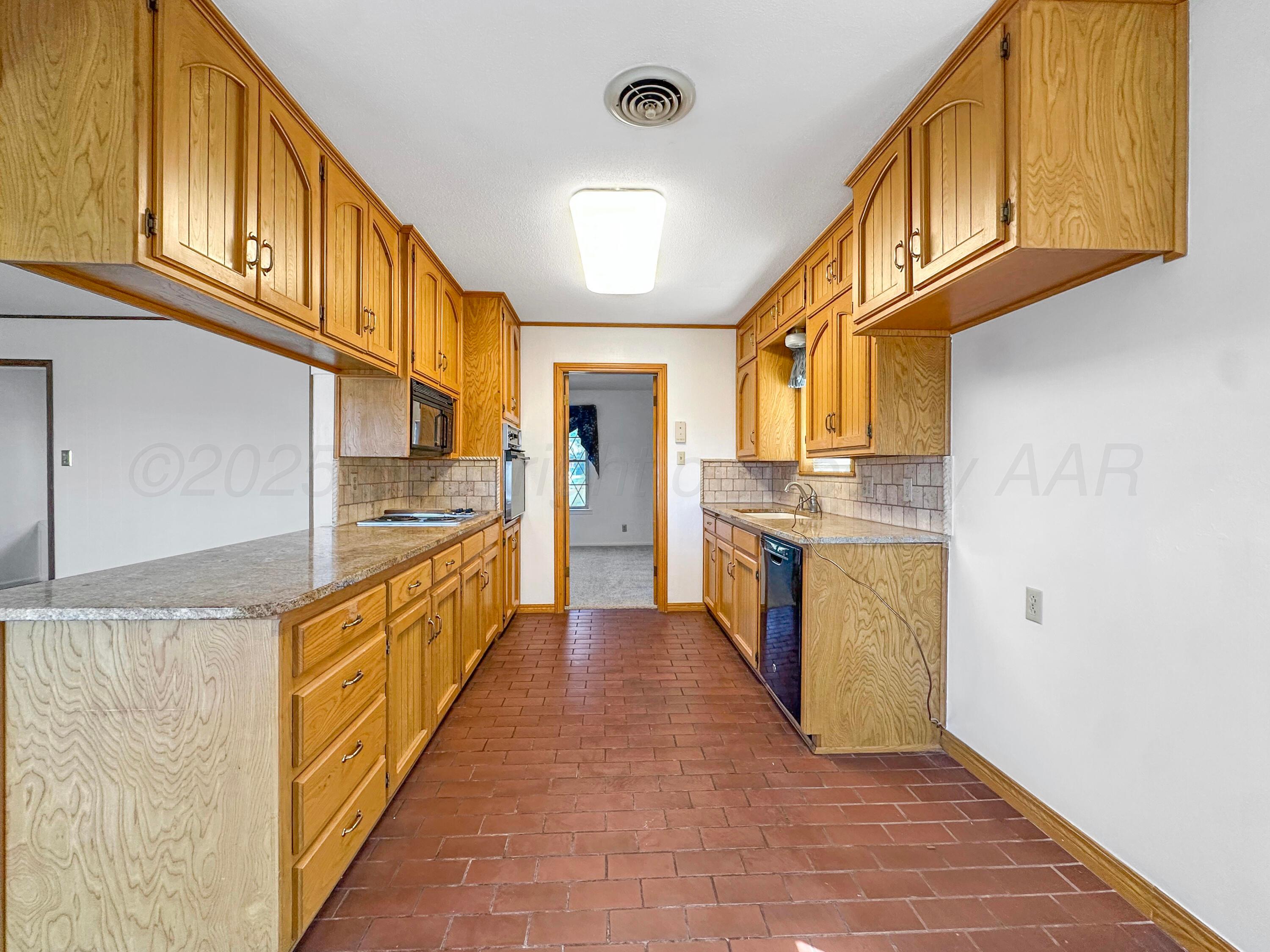 1421 Marigold Street Borger, TX 79007 - Photo 8 of 26 a kitchen with stainless steel appliances granite countertop a refrigerator a stove and a sink