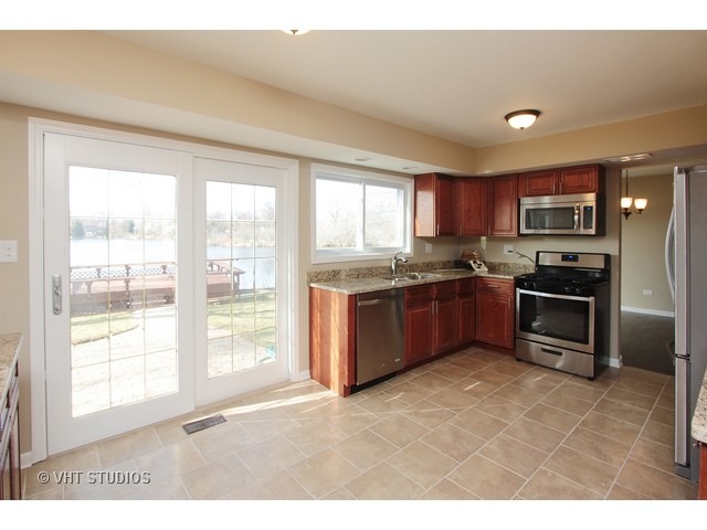 382 Northgate Road Lindenhurst, IL 60046 - Photo 4 of 10 a kitchen with stainless steel appliances granite countertop a stove a sink dishwasher a refrigerator and a microwave