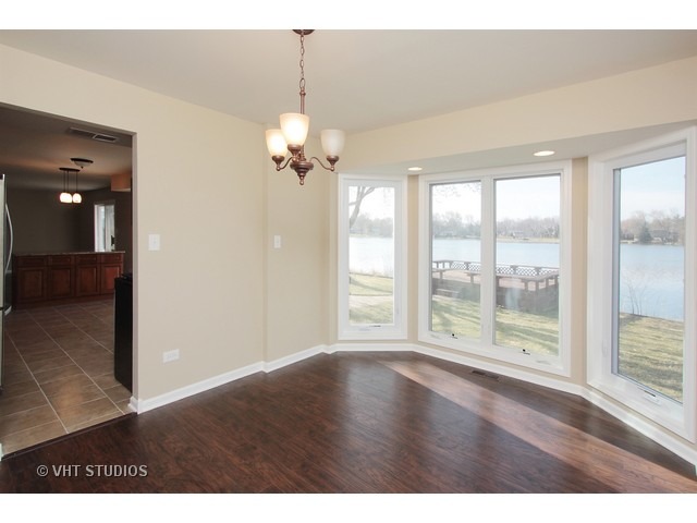 382 Northgate Road Lindenhurst, IL 60046 - Photo 5 of 10 a view of an empty room with wooden floor and a window