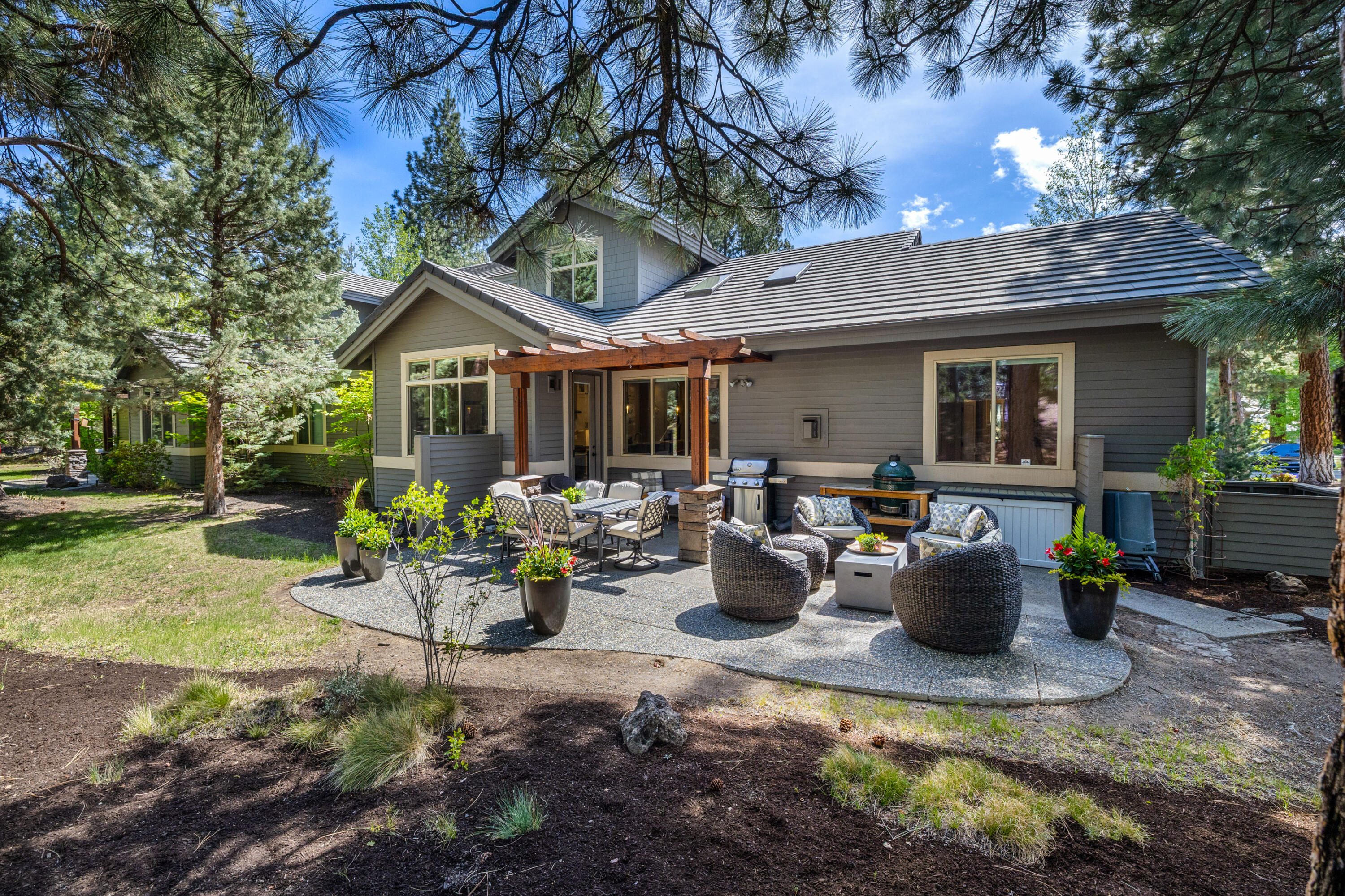 19460 Chip Shot Lane Bend, OR 97702 - Photo 2 of 56 a view of a patio with table and chairs potted plants and a large tree