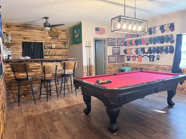 a room with pool table and windows