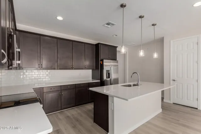 a kitchen with a sink a counter space appliances and cabinets