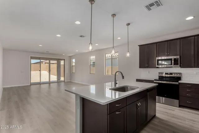 a kitchen with granite countertop a sink a counter space appliances and cabinets